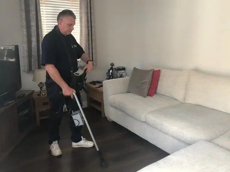 An ADI engineer walking a living room floor with a tracer gas probe